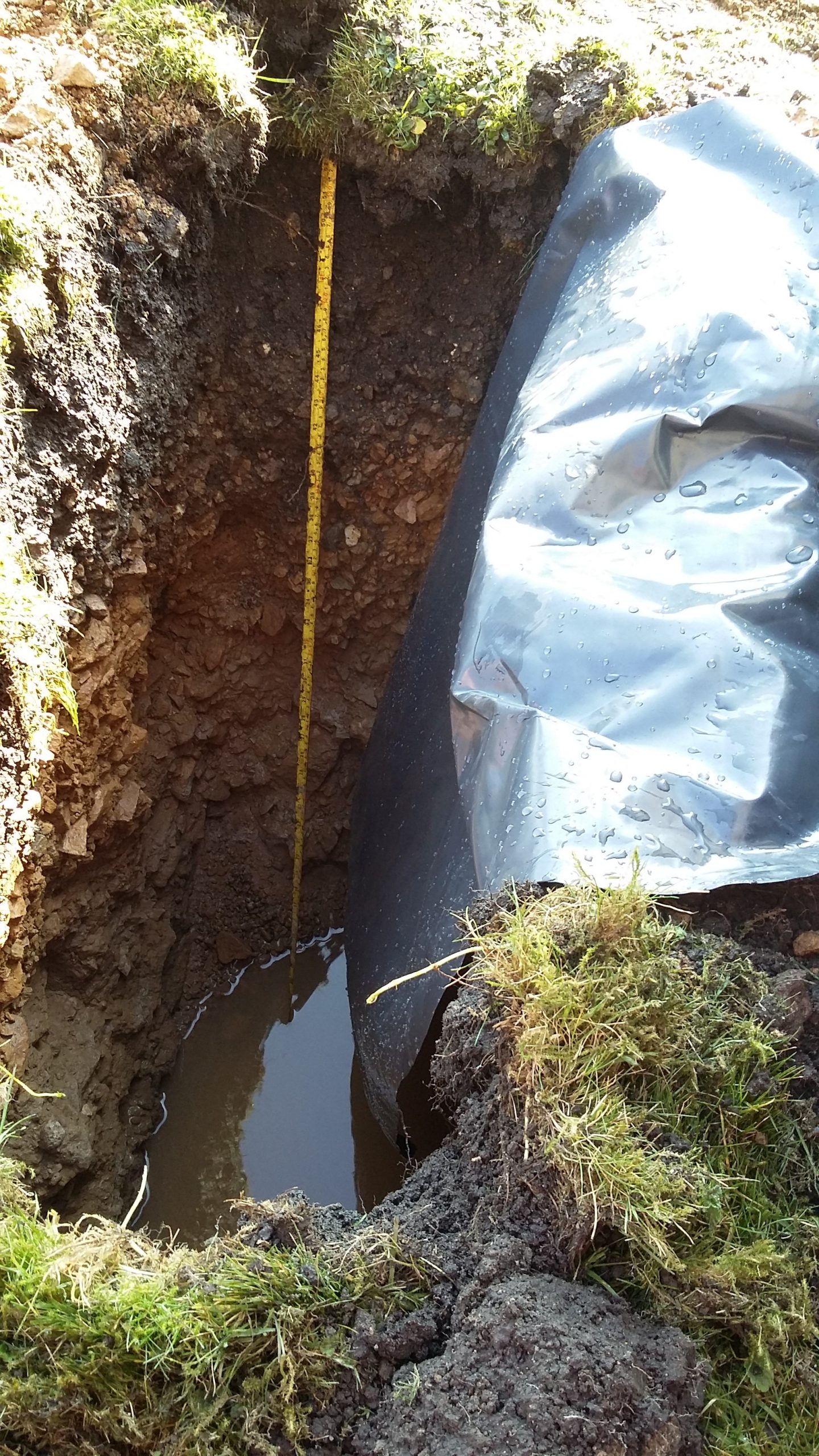 Soakaway trial hole being filled with water near West Midlands
