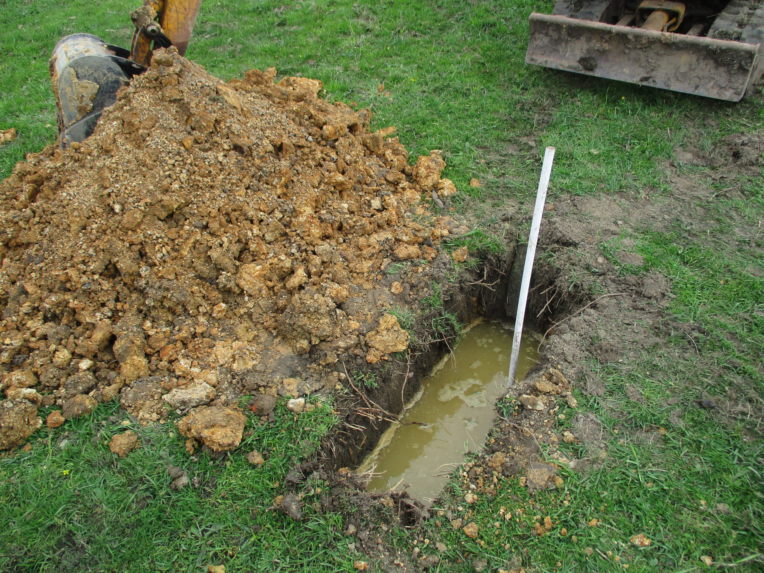 Soakaway trial hole being filled with water near Bromsgrove