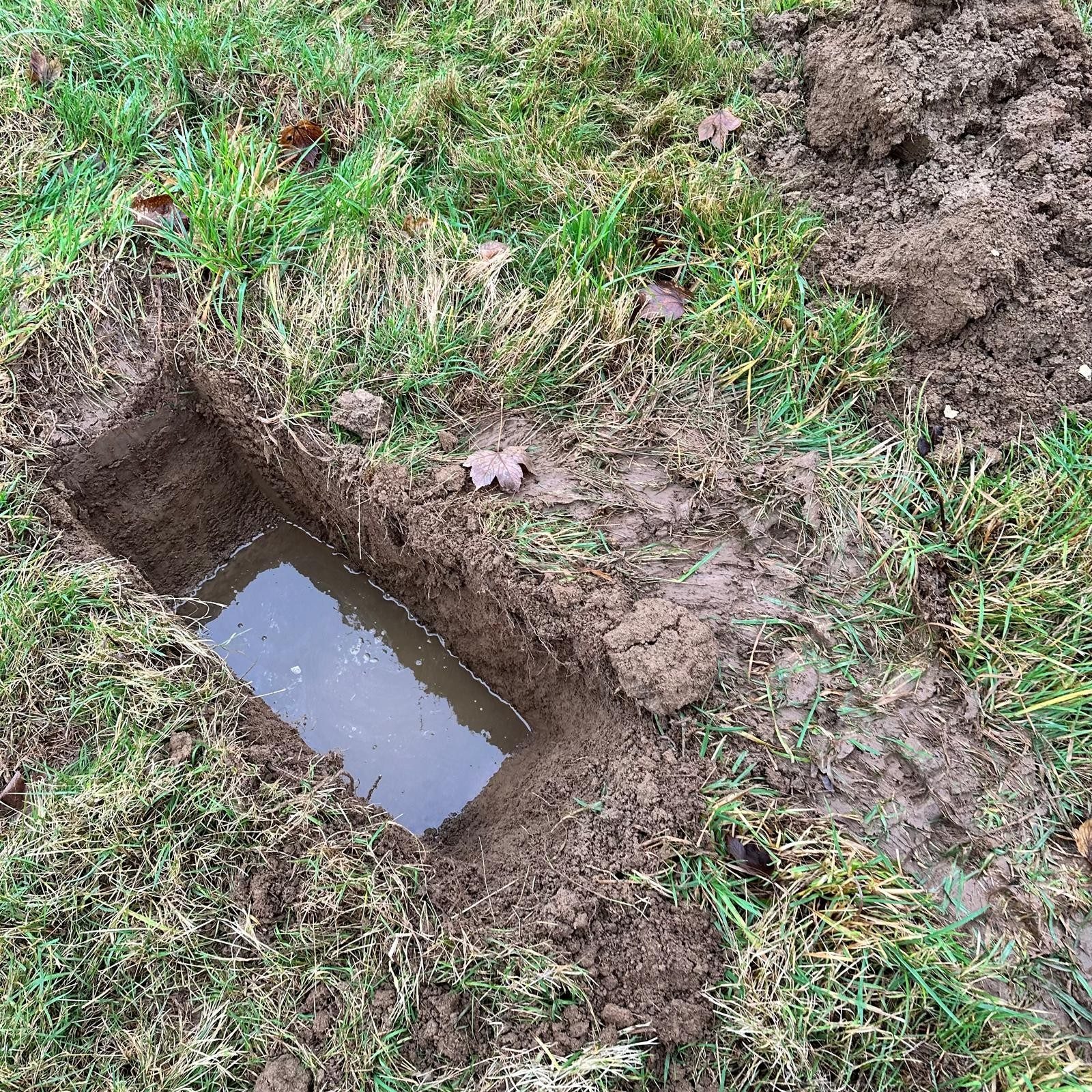 Soakaway trial hole being filled with water near Cheltenham