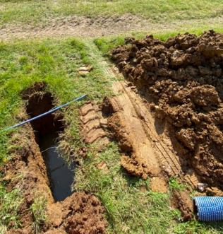 Soakaway trial hole being filled with water near Malvern
