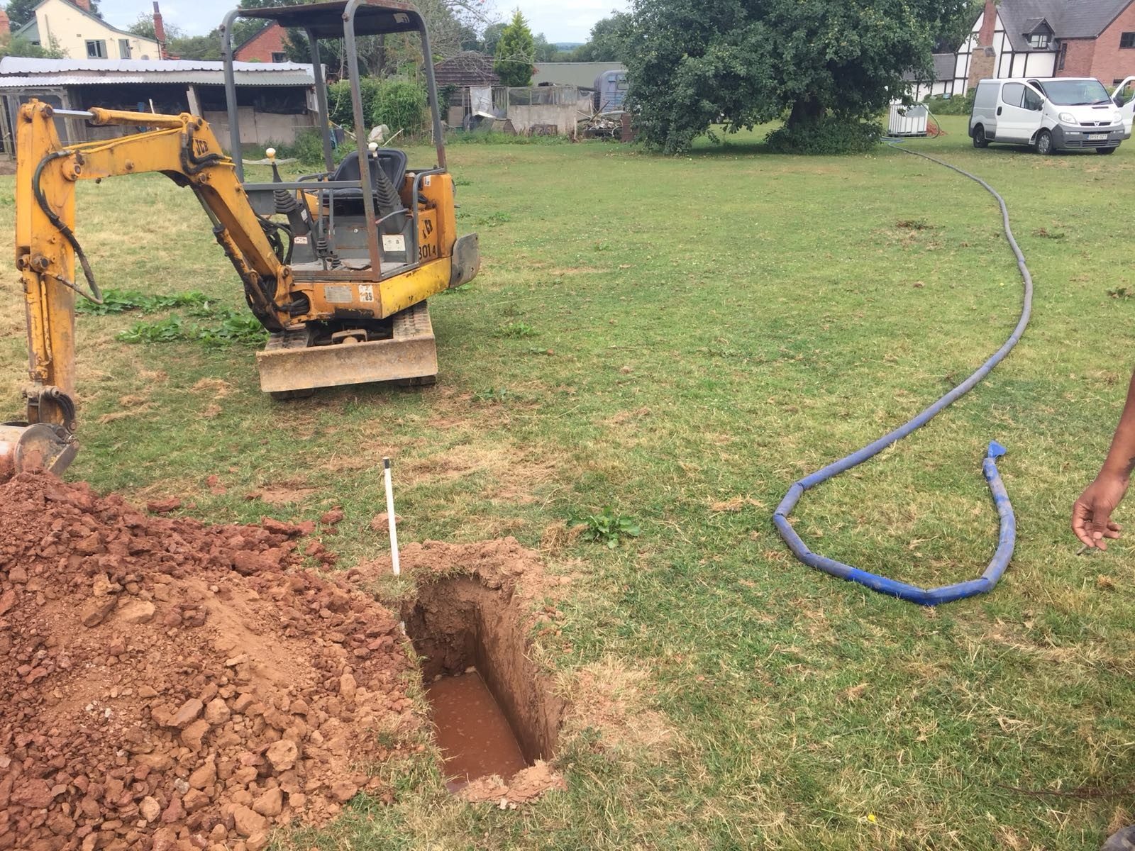 Soakaway trial hole being filled with water near Leamington Spa
